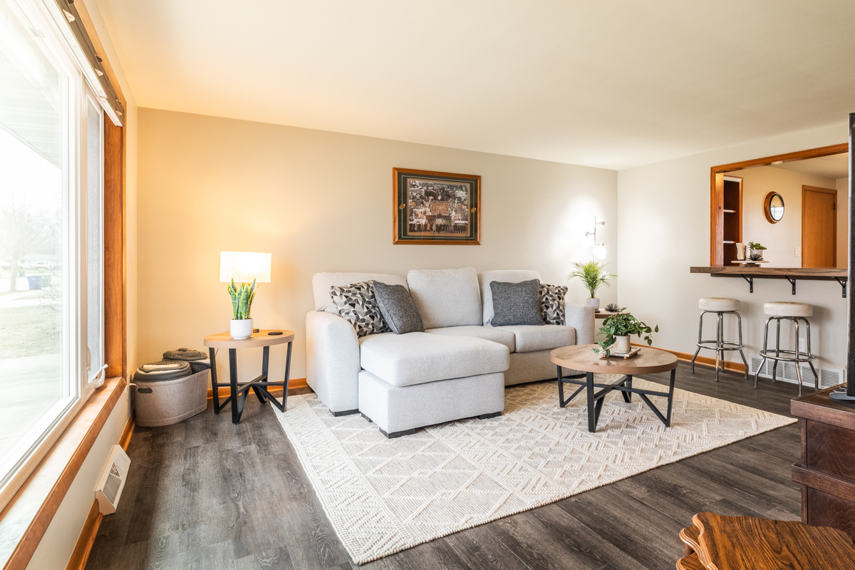 a shot of a living room with the eat in kitchen in the background