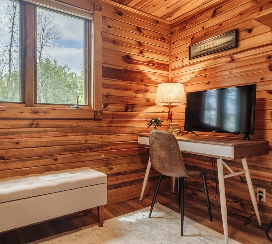 Office nook with desk, monitor, fan, and extra clothing storage
