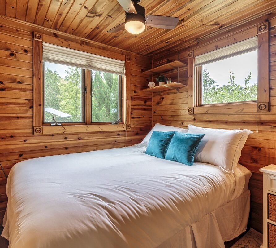 Cozy queen bedroom with ceiling fan and natural light